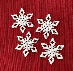 crochet snowflakes on a red surface with white thread and beading