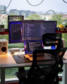 two computer monitors sitting on top of a desk next to a keyboard, mouse and speakers