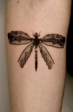 a black and white photo of a dragonfly tattoo