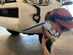 a man working on the front bumper of a car