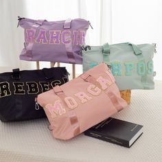 three bags sitting on top of a table next to a book and a bag with letters