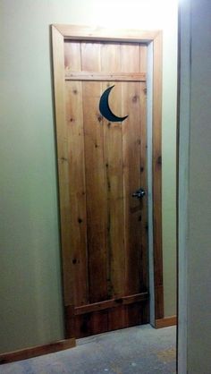 an open door with a crescent moon on the front and side panel in between two walls