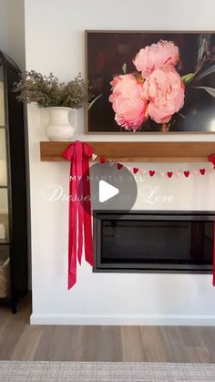 a fireplace decorated with pink flowers and red ribbon for valentine's day decorating