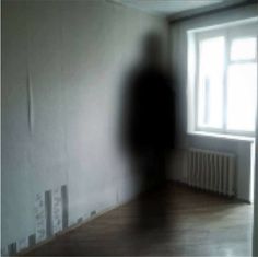 a blurry image of a person standing in front of a window with the light coming through