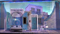 a woman standing in front of a blue and white building