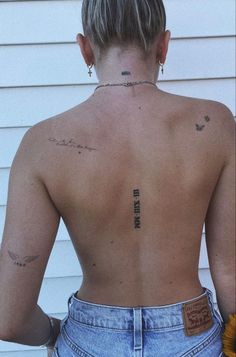 the back of a woman's body with tattoos on her upper and lower back