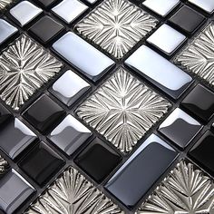 a close up view of a glass and metal mosaic tile design with black, silver, and white colors