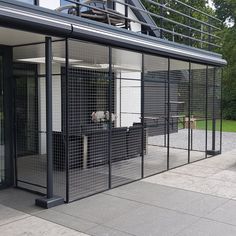 an enclosed patio with sliding glass doors on the side and black metal railing around it