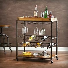 a bar cart with wine glasses and bottles on it