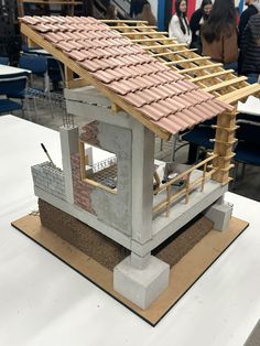 a model of a house with a roof made out of bricks and wood planks