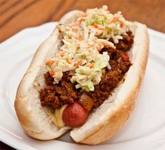 a chili dog on a plate with coleslaw