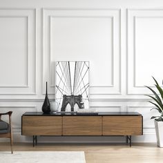 a living room scene with focus on the sideboard and vase in the foreground