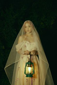 a woman in a wedding dress holding a lantern