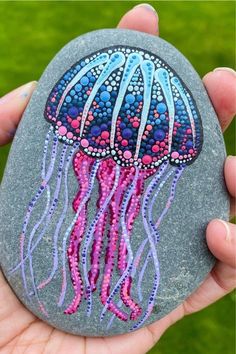 a hand painted rock with a jellyfish on it