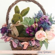 a stuffed rabbit sitting in a basket with flowers