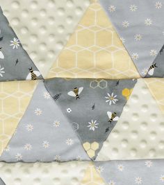 a close up of a patchwork quilt with bees and flowers