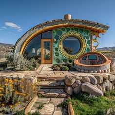 a house made out of rocks and stones with a circular window on the front door