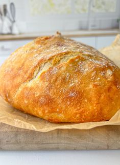 a loaf of bread sitting on top of a wooden cutting board