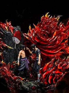 two figurines standing next to each other on a black surface with red flames