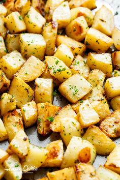 cooked potatoes with herbs and seasoning on a baking sheet, ready to be eaten