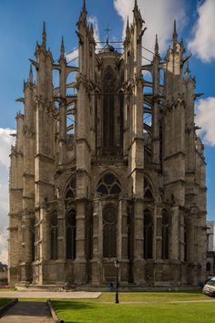 the large cathedral has many spires on it's sides and is surrounded by lush green grass