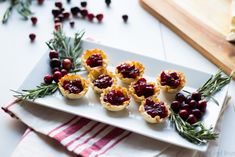 small appetizers with cranberry sauce and rosemary on a white platter