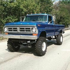 a large blue truck is driving down the road