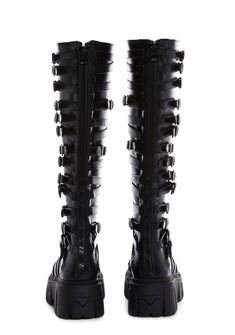 in a vegan leather construction. These knee high boots have decorative buckles on both sides, treaded soles, and back zipper closures. Alternative Style Boots With Buckle Closure, Gothic Leather Knee-high Boots, Gothic Leather Knee-high Boots For Alternative Fashion, Edgy Knee-high Boots With Buckle Closure, Black Punk Knee-high Boots With Buckle, Black Punk Knee-high Boots With Buckle Closure, Black Punk Style Knee-high Boots With Buckle, Black Knee-high Moto Boots With Zipper Closure, Punk Style Leather Knee-high Boots With Buckle