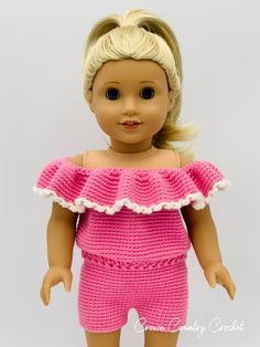 a doll with blonde hair wearing a pink crochet top and short pants on a white background