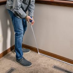 a man standing on the floor with a stick in his hand