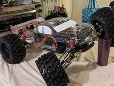 a remote control car on a table in a room with other electronics and accessories around it