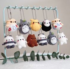 there are many crocheted keychains hanging from a rack on the table