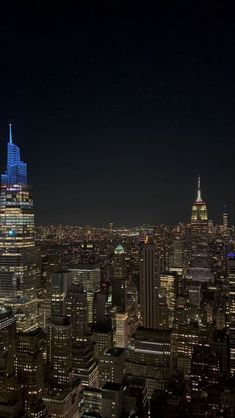 an aerial view of new york city at night with the empire building lit up in blue