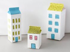 three small houses made out of paper sitting next to each other