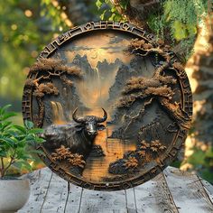 an artistically designed plate with a bull in the middle on a wooden table next to a potted plant