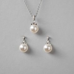 Simple yet alluring pearl earrings and necklace set. A single pearl hangs from a micro CZ accented drop for a little sparkle to your style. They are both about .75 inches long with a 10mm pearl and the necklace is 16 inches with a 2-inch extender. Available in rhodium or gold plate, they are lead, nickel, and cadmium-free. Wedding Pearl Jewelry Set, Single Pearl Necklace Silver, Pearl Earrings And Necklace, Wedding Necklace Set, Single Pearl Necklace, Earrings And Necklace Set, Vibe Check, Single Pearl, Bridal Necklace Set