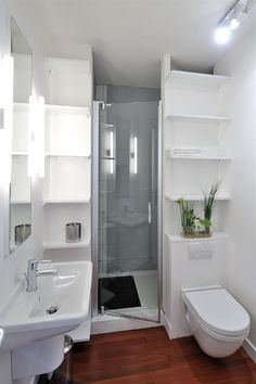 a bathroom with a toilet, sink, and shower stall in the middle of it