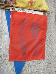 an orange and blue kite with some writing on it