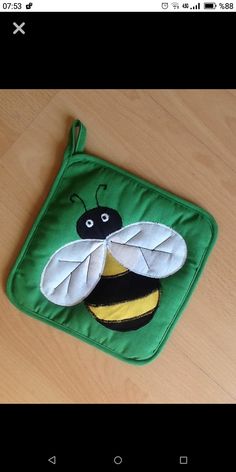 a small green bag with a bee on it