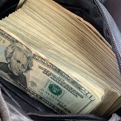 an open backpack filled with money sitting on top of it