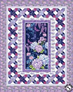 a purple and white quilt with flowers on the border, in front of a checkered background