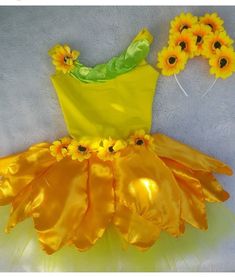 a yellow dress with sunflowers on it and some hair pins in the shape of flowers