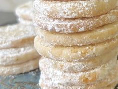 a stack of powdered sugar donuts sitting on top of a blue plate