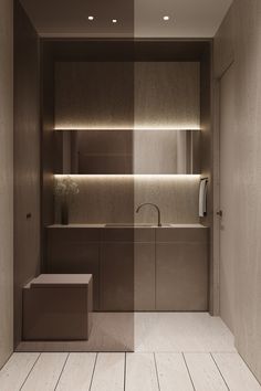 an empty bathroom with wooden flooring and lighting on the wall, along with two sinks