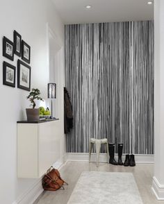 the hallway is decorated with black and white striped wallpaper, along with an area rug