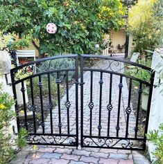 an iron gate in the middle of a garden