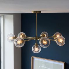 a chandelier hanging from the ceiling in a room with blue walls and windows