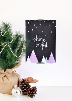 a christmas tree in front of a black board with the words shine bright on it