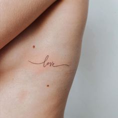 a woman's back with the word love written on it, in cursive font