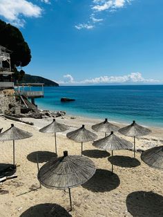 there are many umbrellas that are on the beach by the water's edge